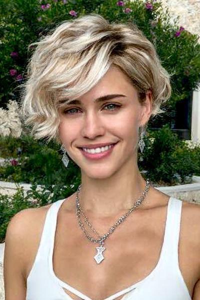 Een vrouw met een vlot, kort kapsel met golvend, lichtblond haar en zijscheiding.