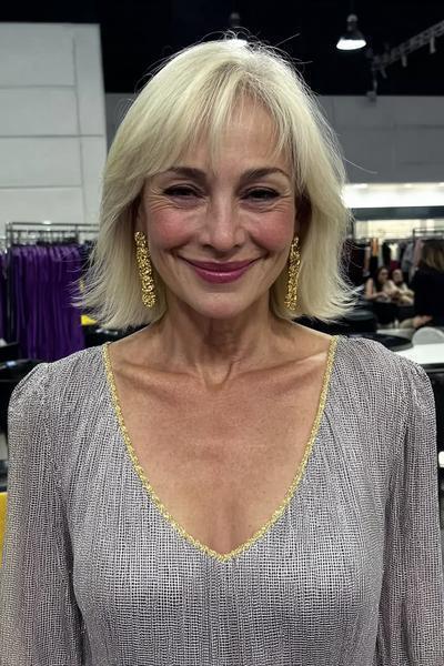Een oudere dame met een stijlvolle, kinlange blonde bobkapsel met zachte laagjes en licht golvende pony.