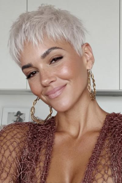 Een vrouw met een vlot, kort pixiekapsel in een lichte blonde kleur.