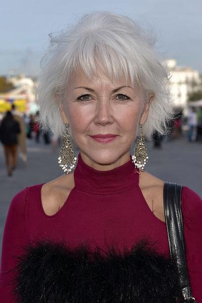 Een oudere dame met een korte, warrige witte bobkapsel en een lichte pony aan de voorkant.