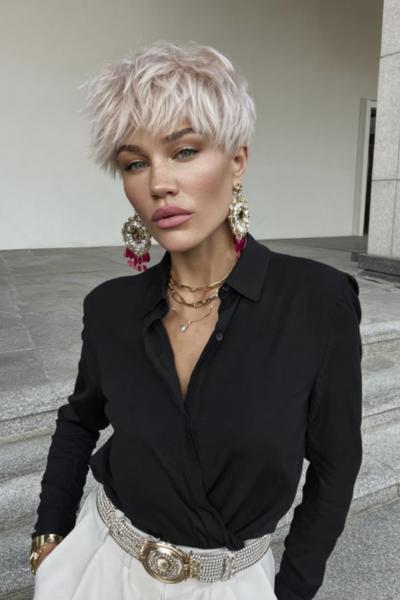 Een vrouw met een trendy, kort vlot kapsel met een warrige, blonde coupe en een pony.