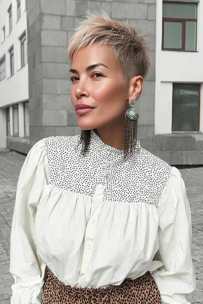 Een vrouw met een vlot, kort kapsel met blonde highlights en een asymmetrische pony.