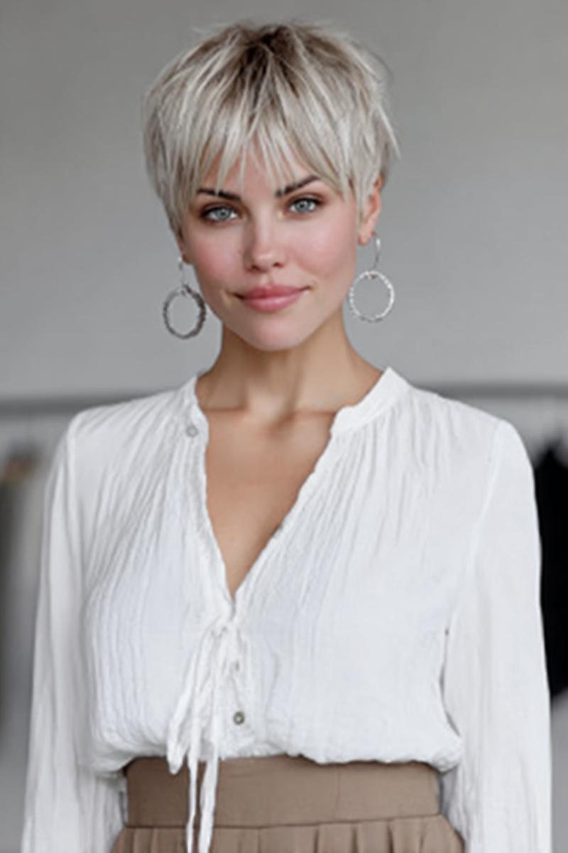 Een vrouw met een kort, trendy pixiekapsel met lichtblond haar en speelse, gelaagde lokken aan de voorkant.