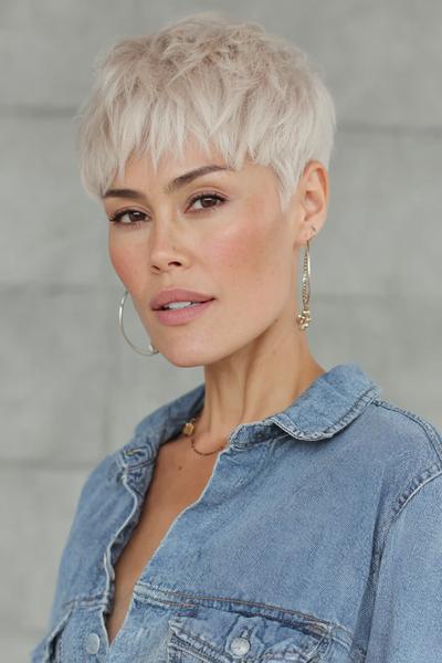 Een vrouw met een vlot, kort kapsel en geplatiniseerd blond haar in een pixie cut.