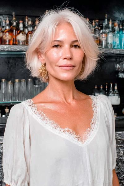 Een oudere dame met een stijlvolle, kinlange witte bobkapsel met een midden scheiding en zachte, volumineuze lagen.