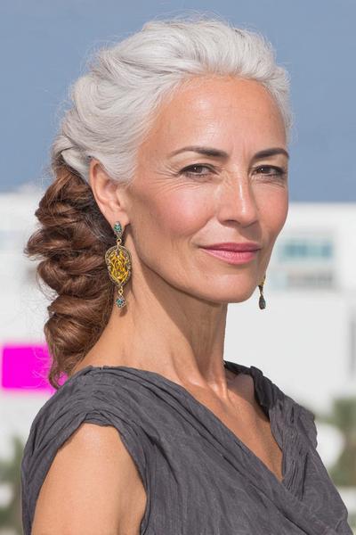 Een oudere dame met golvend grijs haar dat aan de achterkant is opgestoken in een elegante, volumineuze stijl.