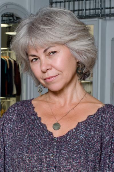 Een oudere dame met een vlot, kort grijs kapsel met veel volume en zachte lagen.