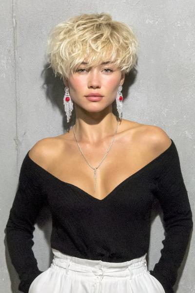 Een vrouw met kort, blond, warrig haar in een speelse pixie cut.