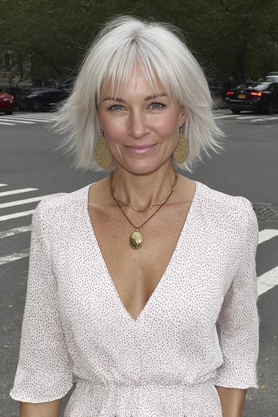 Een oudere dame met een kort, recht bob kapsel met pony en zilverwit haar, dat in lagen is geknipt voor extra volume.