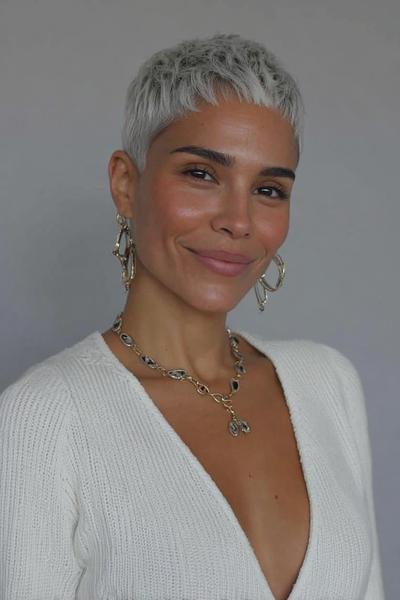 Een vrouw met kort, zilvergrijs haar in een moderne pixie cut.