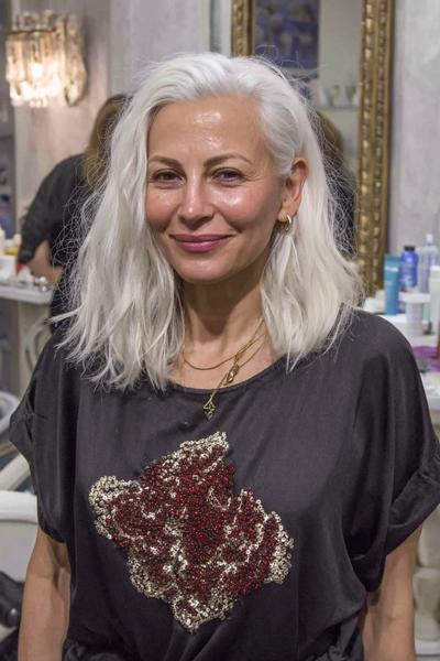 Een oudere dame met halflang, golvend, zilvergrijs haar in een natuurlijke en stijlvolle bob kapsel.