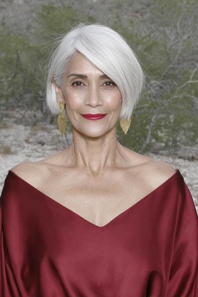 Een oudere dame met een vlotte, asymmetrische bobkapsel en stijlvol wit haar.