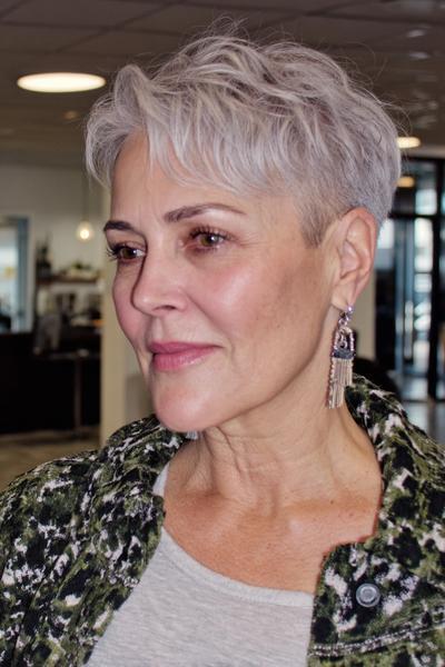Een vrouw met kort, stijlvol grijs haar in een vlotte pixie coupe, geschikt voor dames van 60 plus.