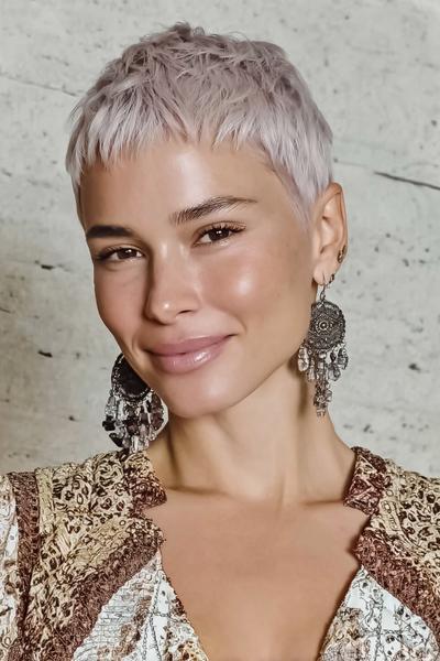 Een vrouw met een vlot, kort pixiekapsel in een lichte, platinablonde kleur.