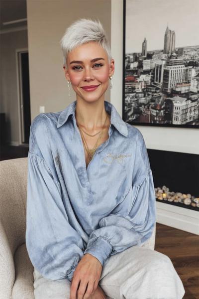 Vrouw met een trendy, kort kapsel met platinablonde, getextureerde lokken die naar boven en opzij zijn gestyled.