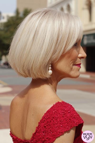 Een oudere dame met een stijlvolle, kinlange blonde bobkapsel met zijscheiding.